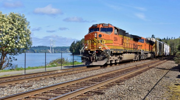 The FRA kicked off April by announcing continued grant program funding availability to help the nation’s railroad’s meet the so-called “PTC Mandate” imposing new control requirements on trains, like this BNSF freight rolling along Puget Sound near Tacoma, Washington on April 2nd, 2016. Photo © 4/2016 by Nikki Burgess; all rights reserved