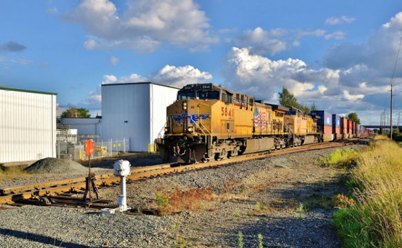 The Union Pacific Railroad, one of the two (with BNSF Railway) major western rail carriers in the United States, had its Positive Train Control implementation plan delivery to the Federal Railroad Administration announced last week. Here a UP trains heads north at Main Street in Auburn, Washington in late August. Image © 8/2016 by Nikki Burgess; all rights reserved.